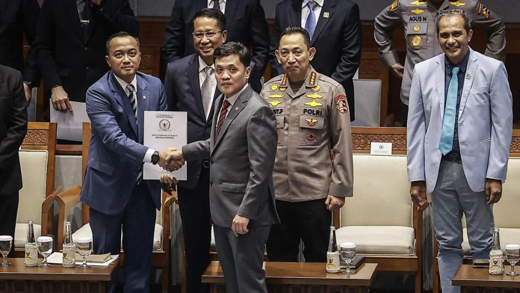 Gambar saat ini: Foto: Mensesneg Prasetyo Hadi (kiri) menerima laporan hasil pembahasan dari Ketua Komisi III DPR Habiburokhman (tengah) pada Rapat Paripurna Ke-21 DPR RI Masa Persidangan V Tahun Sidang 2025-2026 di Kompleks Parlemen, Senayan, Jakarta, Selasa (9/6/2026). Sumber: Istimewa.